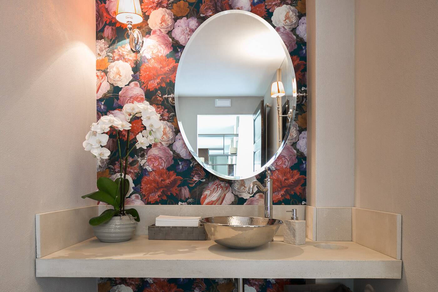 Lavabo in metallo battuto con orchidea bianca e carta da parati a fiori