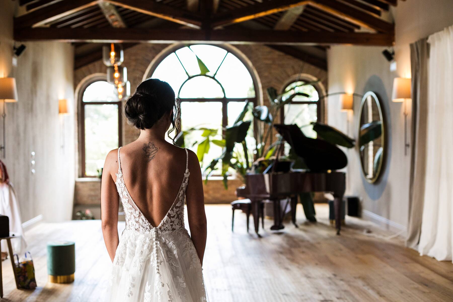 La sposa di spalle, nel Salone del Camino, verso la vetrata ad arco e il pianoforte