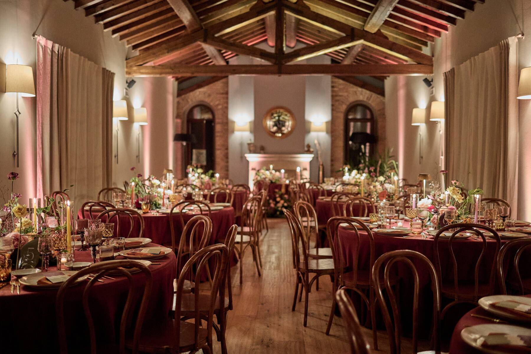 Il Salone del Camino allestito in autunno con tovaglie color bordeaux e candele
