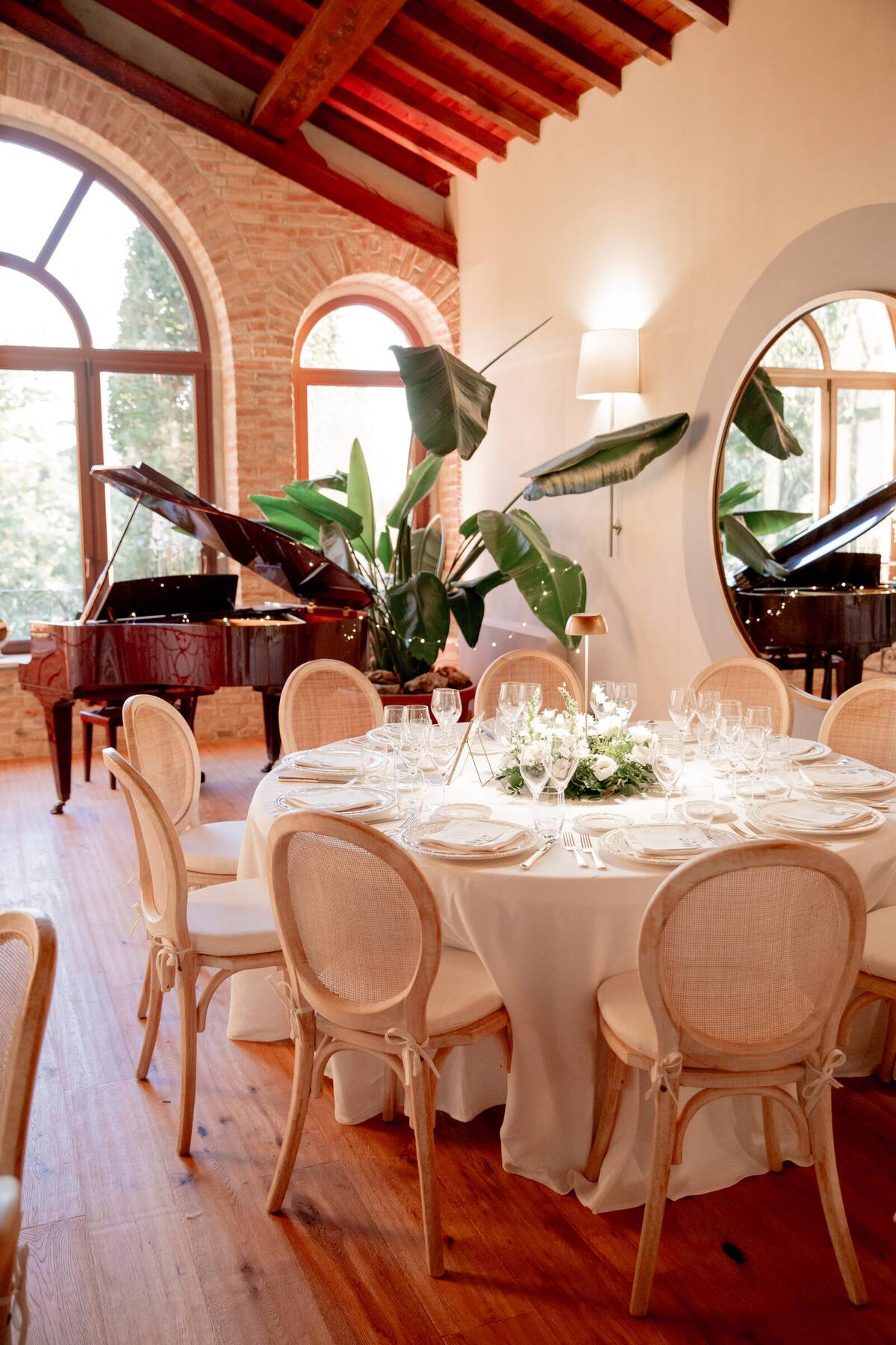 Tavolo apparecchiato con fiori bianchi vicino al pianoforte a coda
