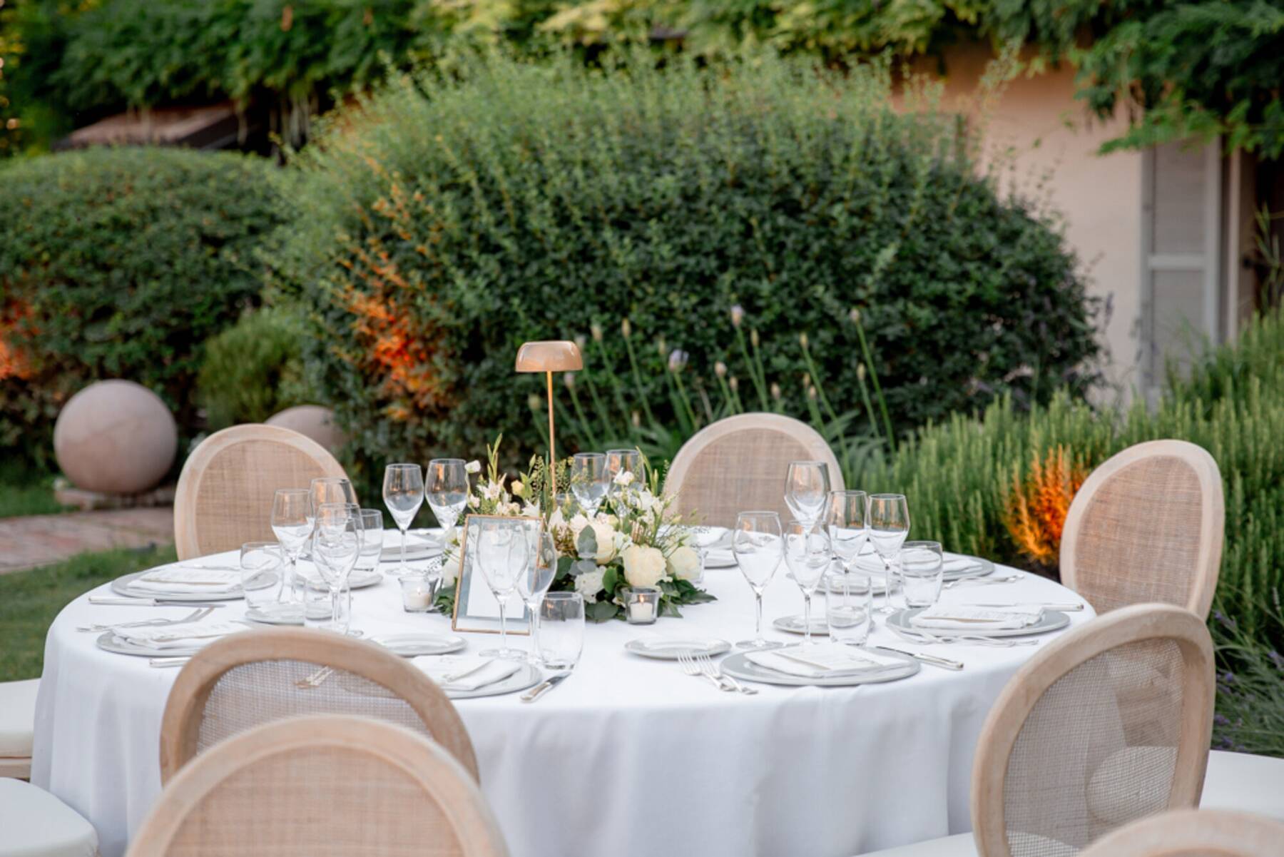 Vista della cena in giardino tra il verde e la casa sullo sfondo